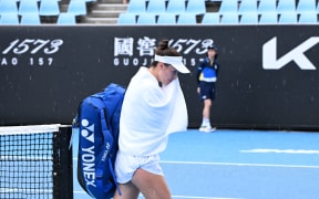 USA's Bernarda Pera walks off the court as rain stops play in the women's singles match against Germany's Tatjana Maria on day one of the Australian Open tennis tournament in Melbourne on January 12, 2025. (Photo by WILLIAM WEST / AFP) / -- IMAGE RESTRICTED TO EDITORIAL USE - STRICTLY NO COMMERCIAL USE --