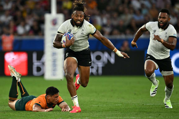 Fiji's outside centre and captain Waisea Nayacalevu, centre, runs with the ball after breaking through a tackle from Australia's centre Lalakai Foketi, left,  during the France 2023 Rugby World Cup Pool C match between Australia and Fiji at Stade Geoffroy-Guichard in Saint-Etienne, south-eastern France on September 17, 2023.