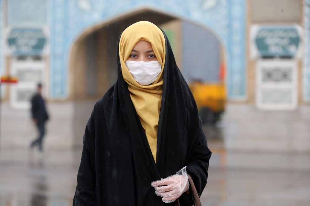A woman wears a respiratory mask after deaths and new confirmed cases revealed from the coronavirus in Qom, Iran on February 25, 2020.