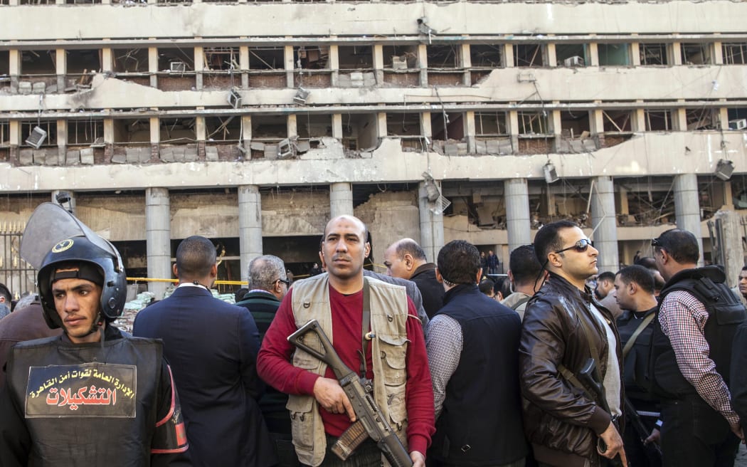 Police guard the damaged facade of the police headquarters in Cairo.