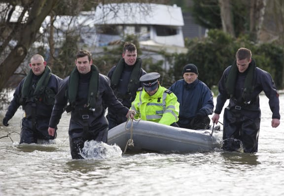 Royal Engineers transport a policeman by boat through floodwaters in Thames Meadow, near Shepperton, south of London.