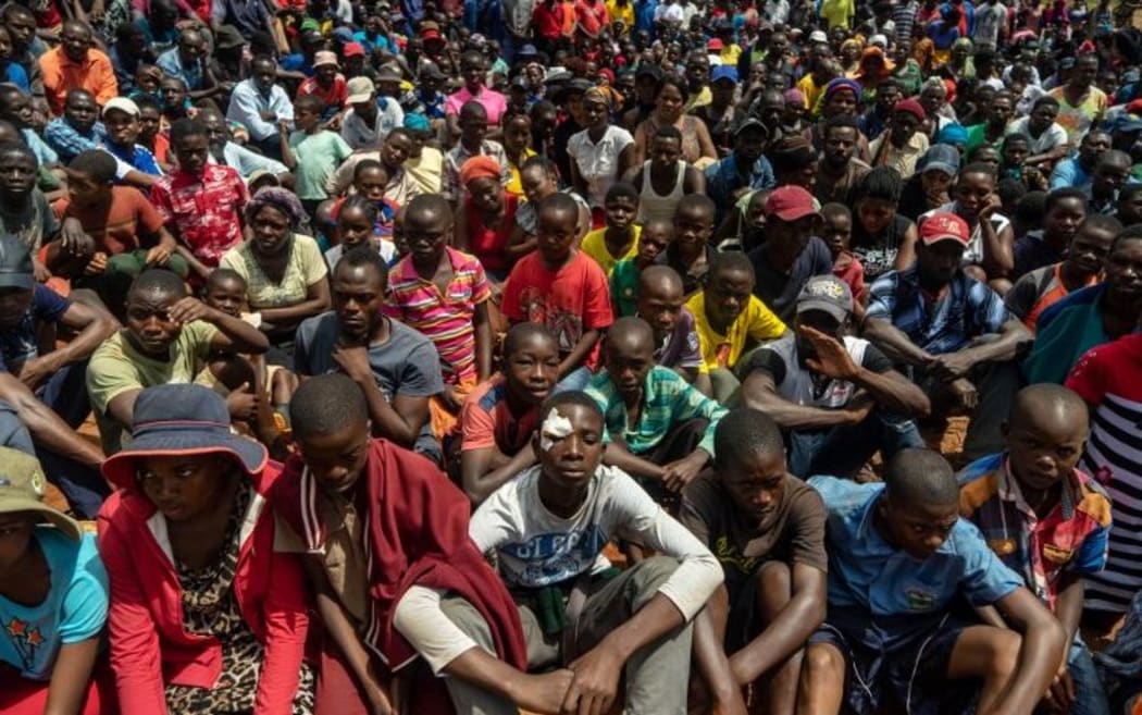 Survivors listen to Zimbabwe's President Emmerson Mnangagwa addressing residents of Ngangu, a township of Chimanimani.