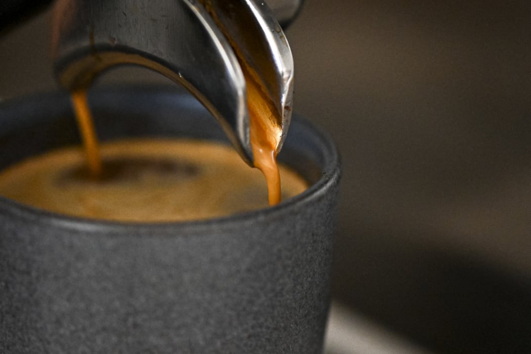 A worker prepares a cup of coffee at a coffee shop in Buenos Aires, on July 19, 2022. Argentina does not produce coffee, it imports it, but the coffee shops in Buenos Aires are an institution that identifies the city and there is even a list of "notable coffees". In the midst of the currency crisis, rise in international prices of raw materials and increase in freight costs, plus a sharp drop in international reserves, Argentines wonder if their daily habits are at risk. (Photo by Luis ROBAYO / AFP)