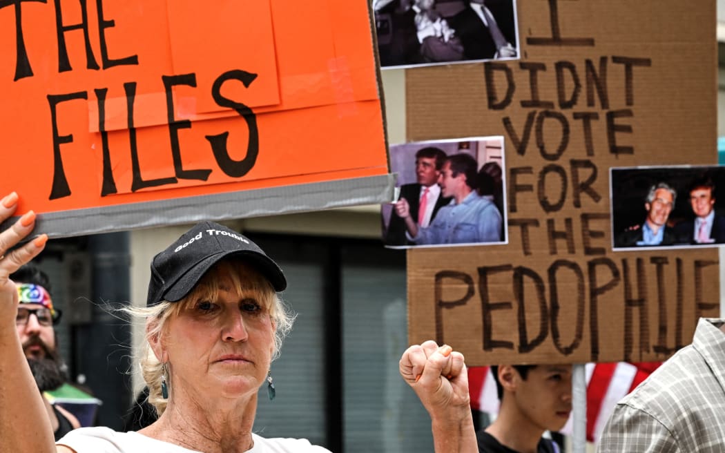 People holds signs calling for the release of files regarding late sex offender Jeffrey Epstein participate in a protest as part of the 'Good Trouble Lives On' national day of action against the administration of US President Donald Trump in Houston, Texas, on July 17, 2025. US President Donald Trump blasted his own supporters and "stupid" Republicans on July 16, 2025, as he went on the attack against anyone questioning his administration's handling of the case of dead sex criminal Jeffrey Epstein. Trump is facing the most serious split in his loyal right-wing base since he returned to power, over claims that his administration is covering up lurid details of disgraced financier Epstein's crimes to protect rich and powerful figures. Epstein died by suicide in a New York prison in 2019 -- during Trump's first term -- after being charged with sex trafficking in a scheme where he allegedly groomed young and underage women for sexual abuse by the rich and powerful. (Photo by RONALDO SCHEMIDT / AFP)