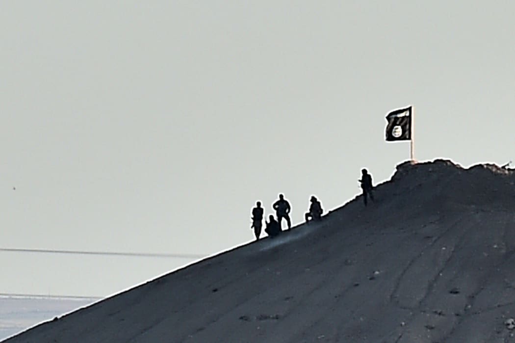 An Islamic State flag on a hill by Kobane - another was on a building on the eastern side of the Syrian border town.