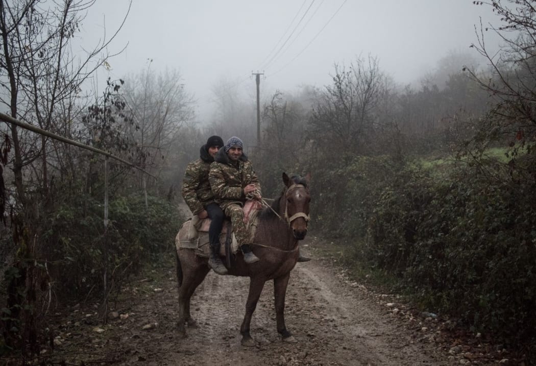 Two men sit on a horse in the village of Taghavard on the contact line between Nagorno-Karabakh and Azerbaijan, Martuni Province, the self-proclaimed Nagorno-Karabakh Republic.