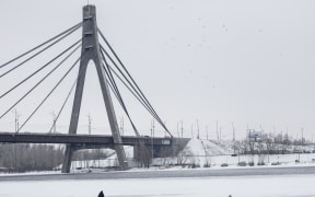 A man walks on the ice covering the frozen Dnipro River in Kyiv, Ukraine on 30 January 2026.