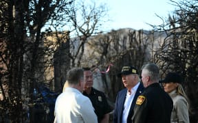 US President Donald Trump and First Lady Melania Trump speak with officials as they tour a fire-affected area in the Pacific Palisades neighborhood of Los Angeles, California, on 24 January, 2025.