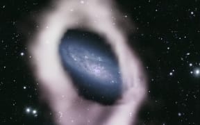 A colourised radio telescope image of the central disk of NGC 4632 surrounded by a thick band of hydrogen gas (white).