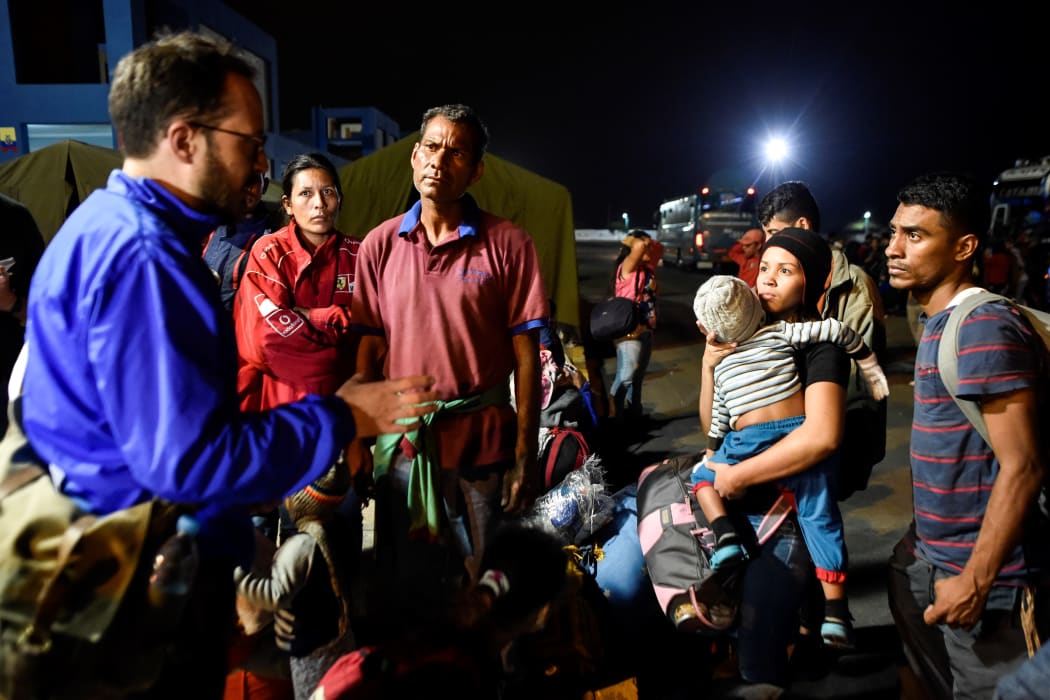 An official of UNHCR speaks with Venezuelan migrants on August 25, 2018, upon their arrival in Huaquillas.