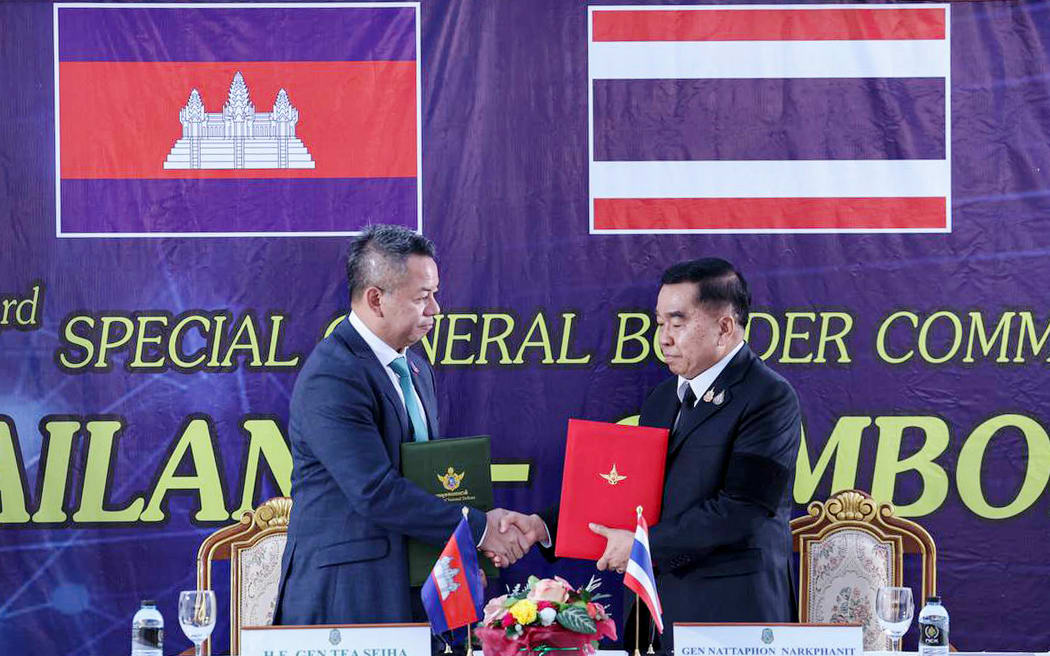Cambodia's defence minister Tea Seiha (L) and Thailand's defence minister Nattaphon Narkphanit (R) shaking hands and exchanging documents during the special General Border Committee (GBC) meeting at a border checkpoint in Thailand's Chanthaburi province.