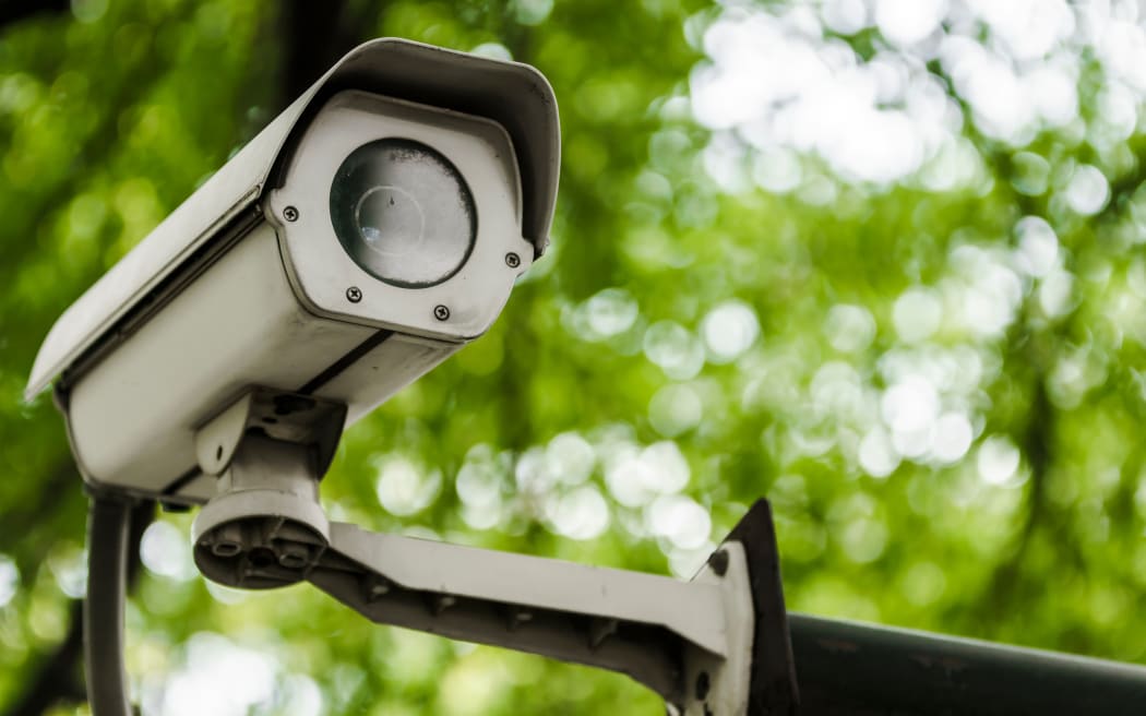 A closed-circuit television camera on green nature background.