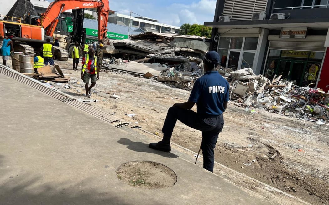 A police person stands and assesses the damage after a 7.3 earthquake struck Port Vila, Vanuatu.