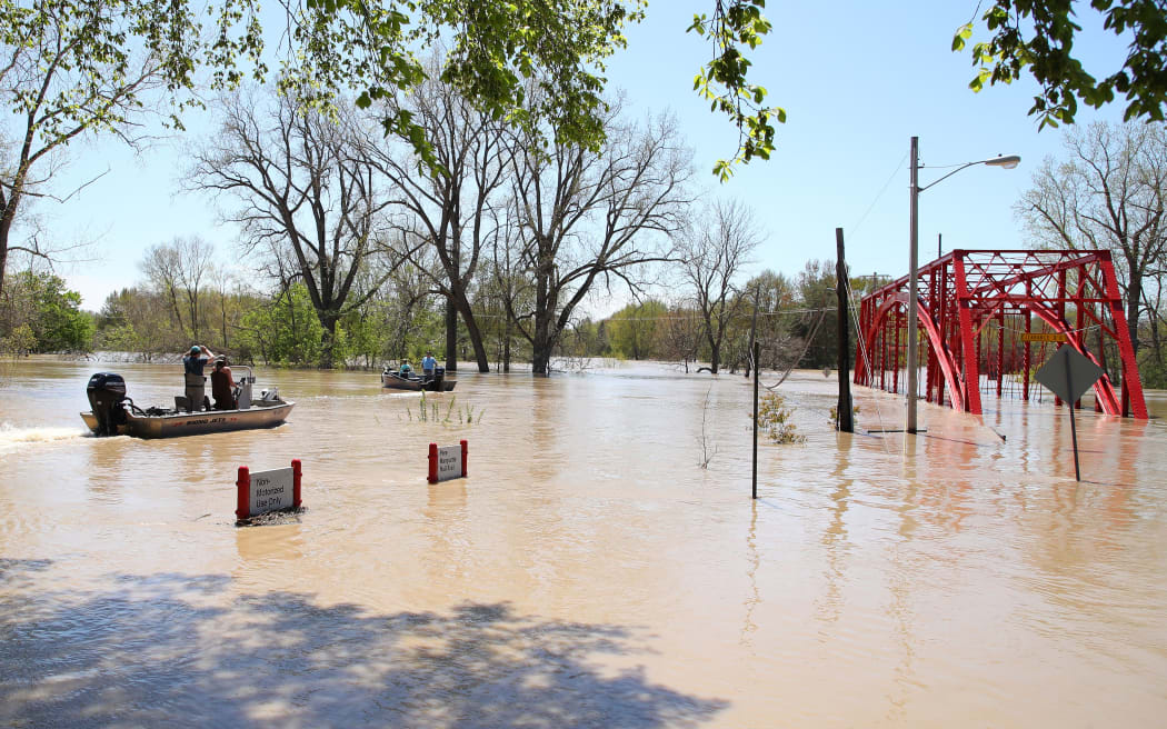 MIDLAND, MICHIGAN - MAY 20: Residents in boats inspect the floodwaters flowing from the Tittabawassee River into the lower part of downtown on May 20, 2020 in Midland, Michigan.
