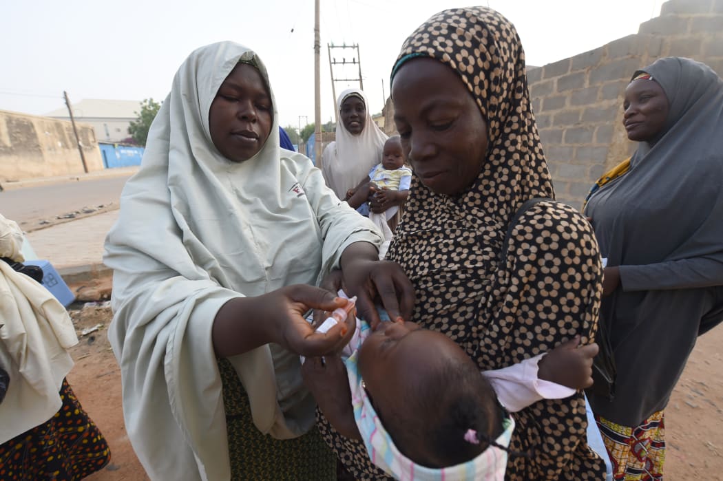 A volunteer health worker tries to immunise a child during a vaccination campaign in north-west Nigeria