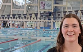 Dunedin swimmer Erika Fairweather in front of a sign of another Olympian from the region Danyon Loader.