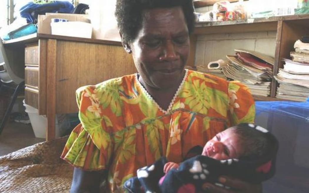 Mary Yalu in Port Vila with grandchild Pamina, born the morning Cylcone Pam struck. The family's home was destroyed in the storm.