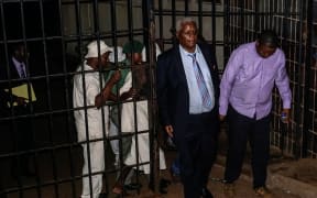 Zimbabwe's former Minister of Finance Ignatius Chombo (second right) leaves Harare Magistrate Court