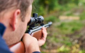 A man aims an air rifle.