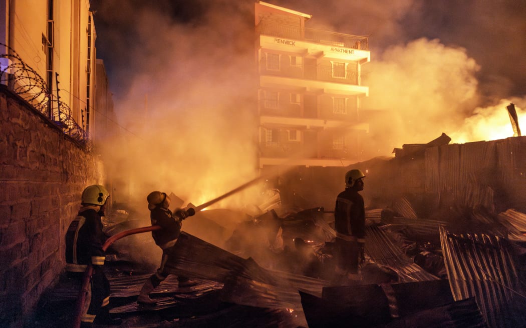 Firemen fight a blaze following a series of explosions in the Embakasi area of Nairobi, Kenya on February 2, 2024. At least 30 people have been transferred to different hospitals, according to the Kenya Red Cross, after explosions rocked an industrial and residential area of the Kenyan capital. (Photo by Luis TATO / AFP)