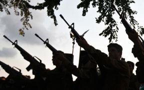 Israeli soldiers fire their weapons during the funeral of a fellow soldier in Holon.