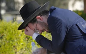 An Ultra-Orthodox Jew mourns at Segula cemetery in Petah Tikva during the funeral of a victim of Jewish pilgrim stampede, on April 30, 2021.