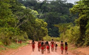 Brazilian Waiapi walk on the road of the Waiapi indigenous reserve, at Pinoty village in Amapa state in Brazil on October 12, 2017.