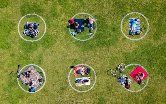 An aerial view shows people gathered inside painted circles on the grass encouraging social distancing at Dolores Park in San Francisco, California on May 22, 2020.
