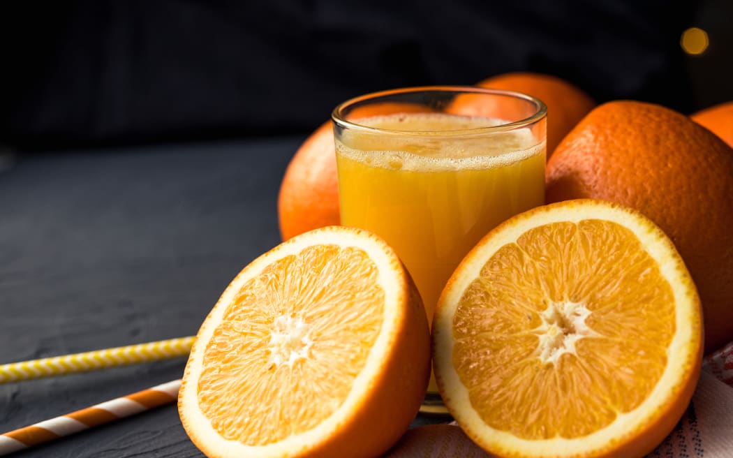 Fresh orange juice and fresh fruit oranges on a black background