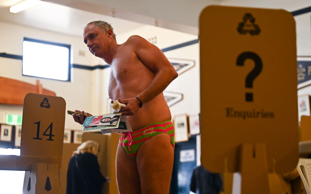 A man votes during Australia's general election at a polling station at Bondi Beach in Sydney on May 21, 2022. (Photo by STEVEN SAPHORE / AFP)