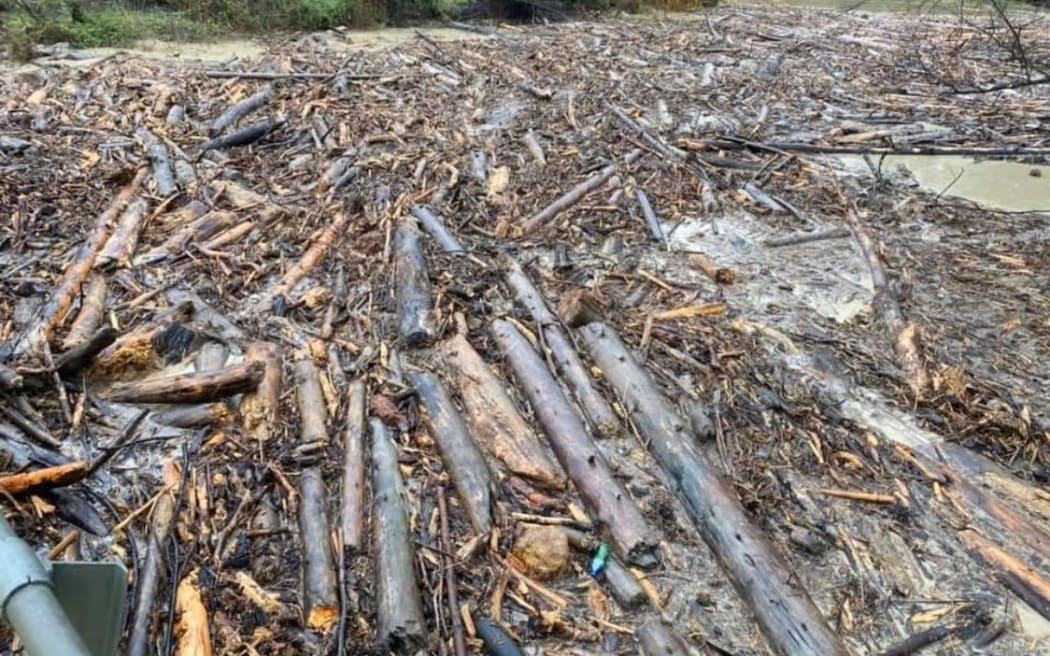 Contractors work to clear logs from as river along Paroa Rd north of Tolaga Bay.