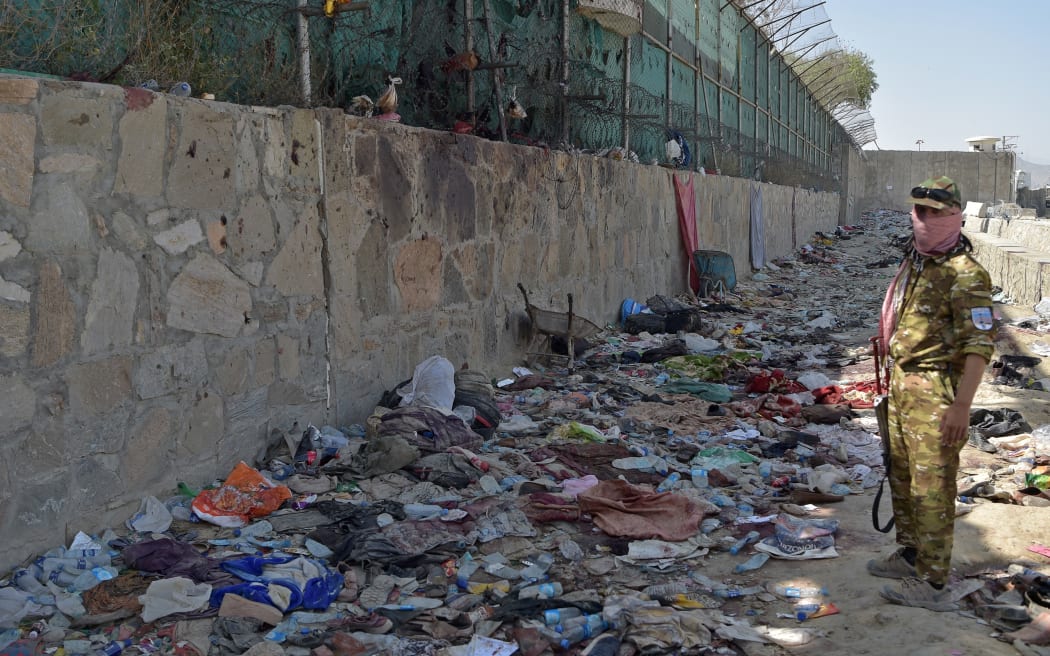A Taliban fighter stands guard at the site of the August 26 twin suicide bombs, which killed scores of people including 13 US troops, at Kabul airport on August 27, 2021.