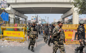 Security personnel patrol on a street following clashes between people supporting and opposing a contentious amendment to India's citizenship law, in New Delhi on February 26, 2020.