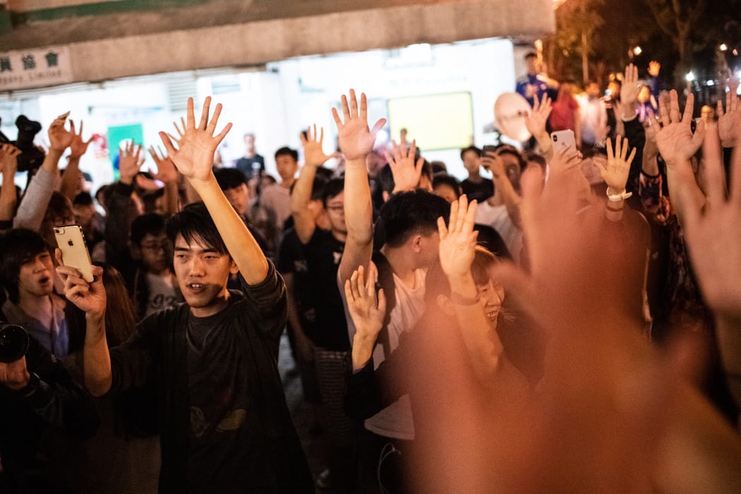 Pro-democracy supporters celebrate after pro-Beijing candidate Junius Ho lost a seat in the district council elections in Tuen Mun district of Hong Kong, early on November 25, 2019.