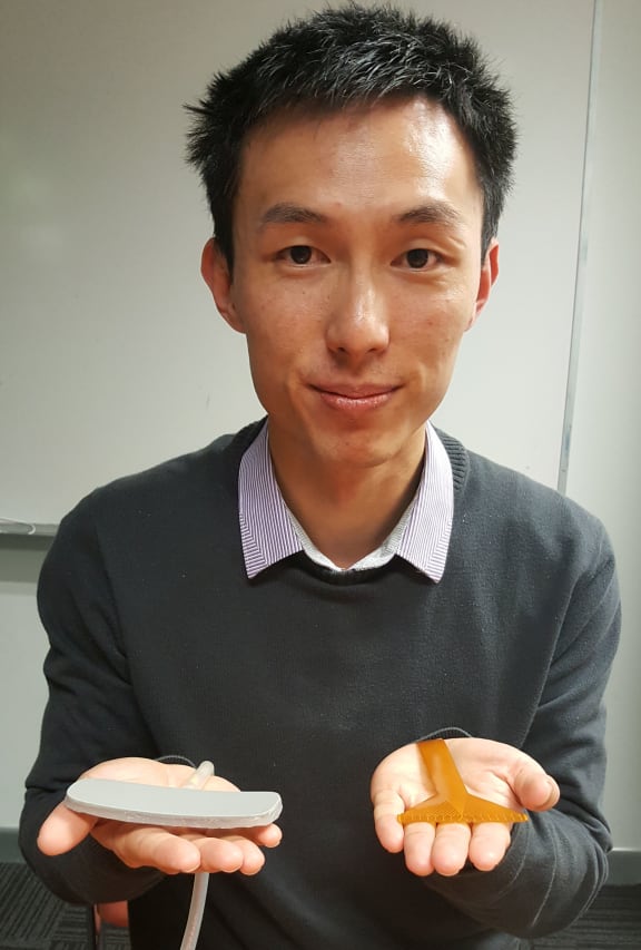 Peng Du holding a rigid electrode that was initially developed by developed by Professor Wim Lammers to detect signals from the gut (left), compared with a more recent flexible electrode (right).