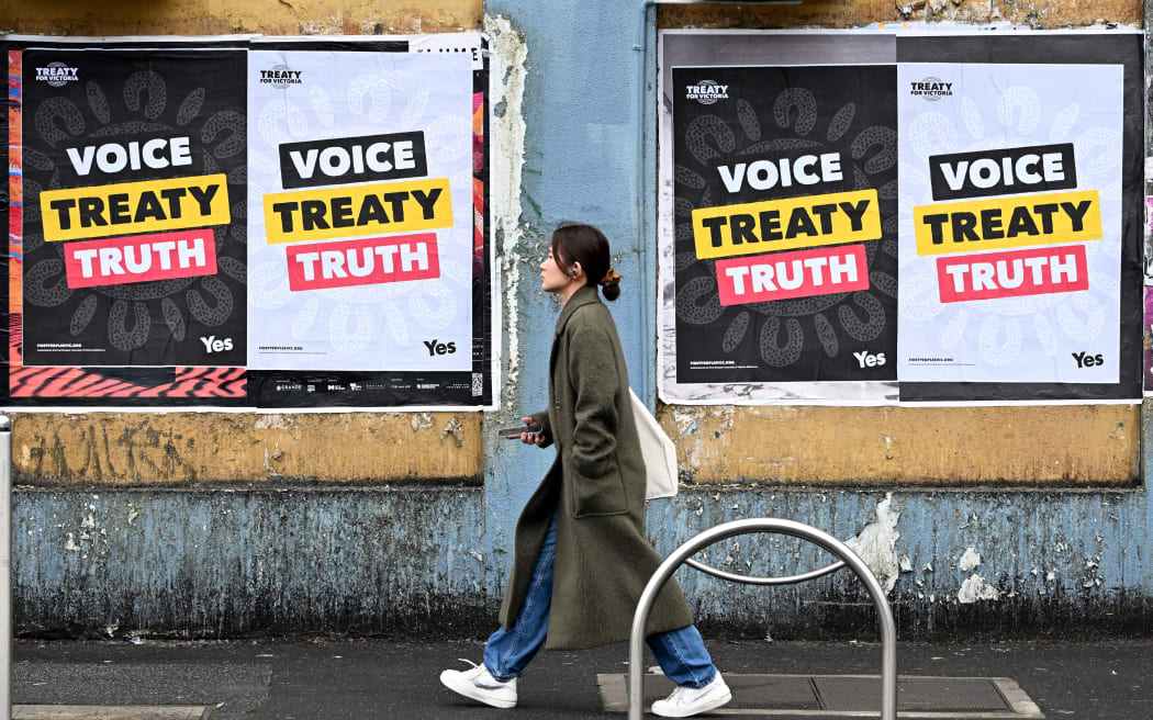 A woman walks past posters advocating for an Aboriginal voice and treaty ahead of an upcoming referendum, in Melbourne on August 30, 2023. Prime Minister Anthony Albanese announced Australia will hold a historic Indigenous rights referendum on October 14 setting up a defining moment in the nation's relationship with its Aboriginal minority. (Photo by William WEST / AFP)