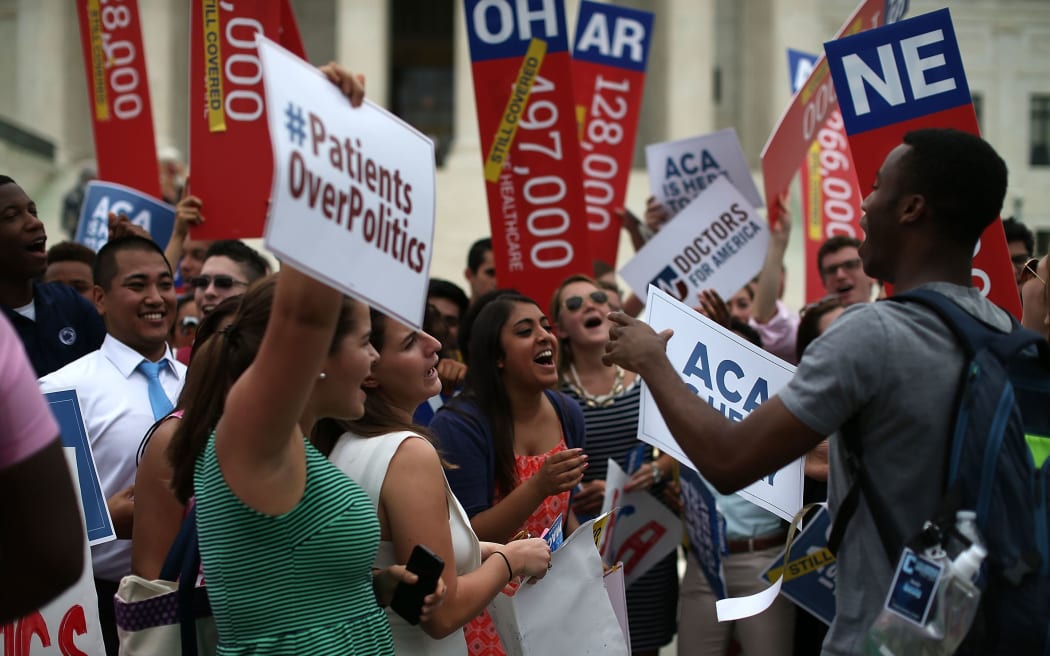 College students celebrate in front of the US Supreme Court after a ruling was announced in favor of the Affordable Care Act.