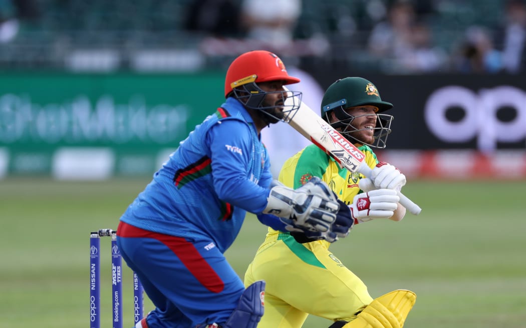David Warner bats (plus wicketkeeper Mohammad Shahzad, left) during the Cricket World Cup match between Australia and Afghanistan at Bristol on 1st June 2019.