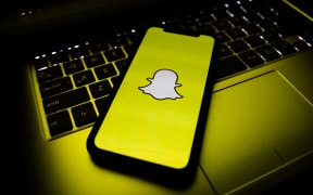 A phone, showing the Snapchat logo.