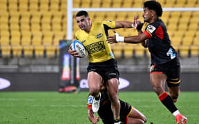 Josh Moorby of the Hurricanes is tackled during the Super Rugby Pacific Hurricanes vs Chiefs match at Sky Stadium in Wellington, New Zealand on 13 April 2024.
