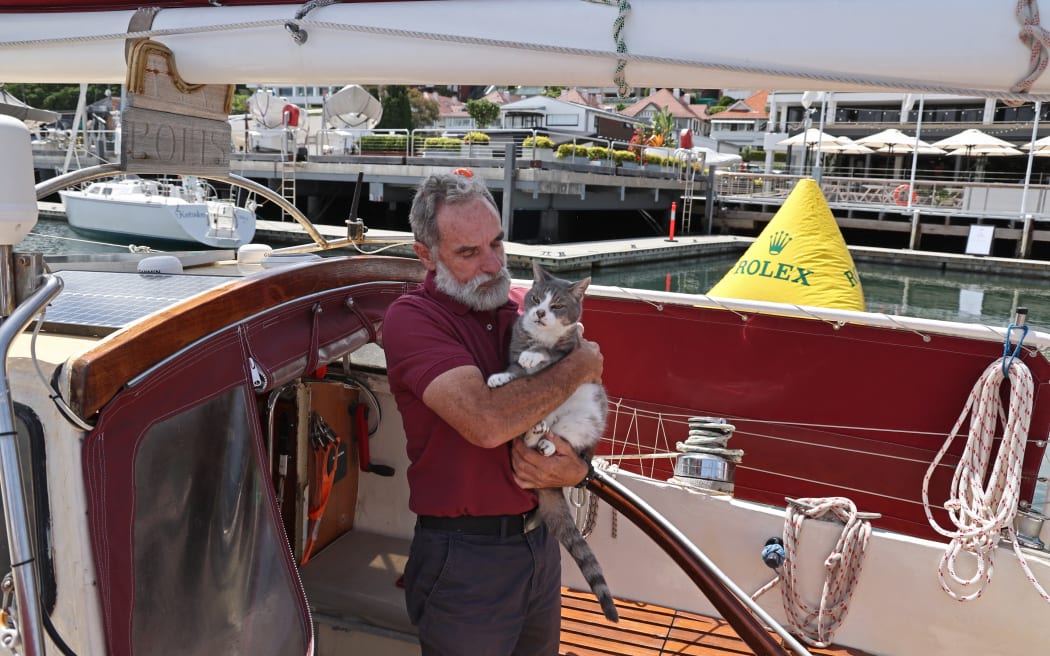 Skipper Robert Williams holds his cat Oli as he stands aboard his yacht ‘Sylph VI’ during the media launch of the Sydney to Hobart Yacht Race in Sydney on November 22, 2023. The 78th running of the 628 nautical mile race has more than 110 yachts entered for the start on Boxing Day on Sydney Harbour.