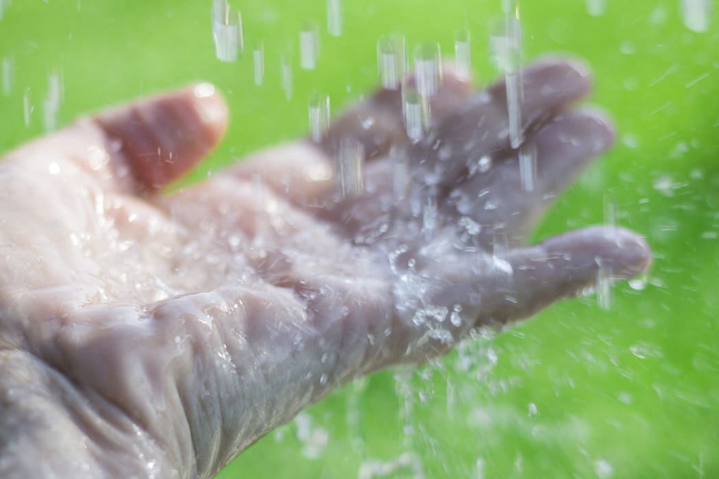 Water splashing on an outstretched hand. (Photo by CRISTINA PEDRAZZINI/SCIENCE PHOT / CPD / Science Photo Library via AFP)