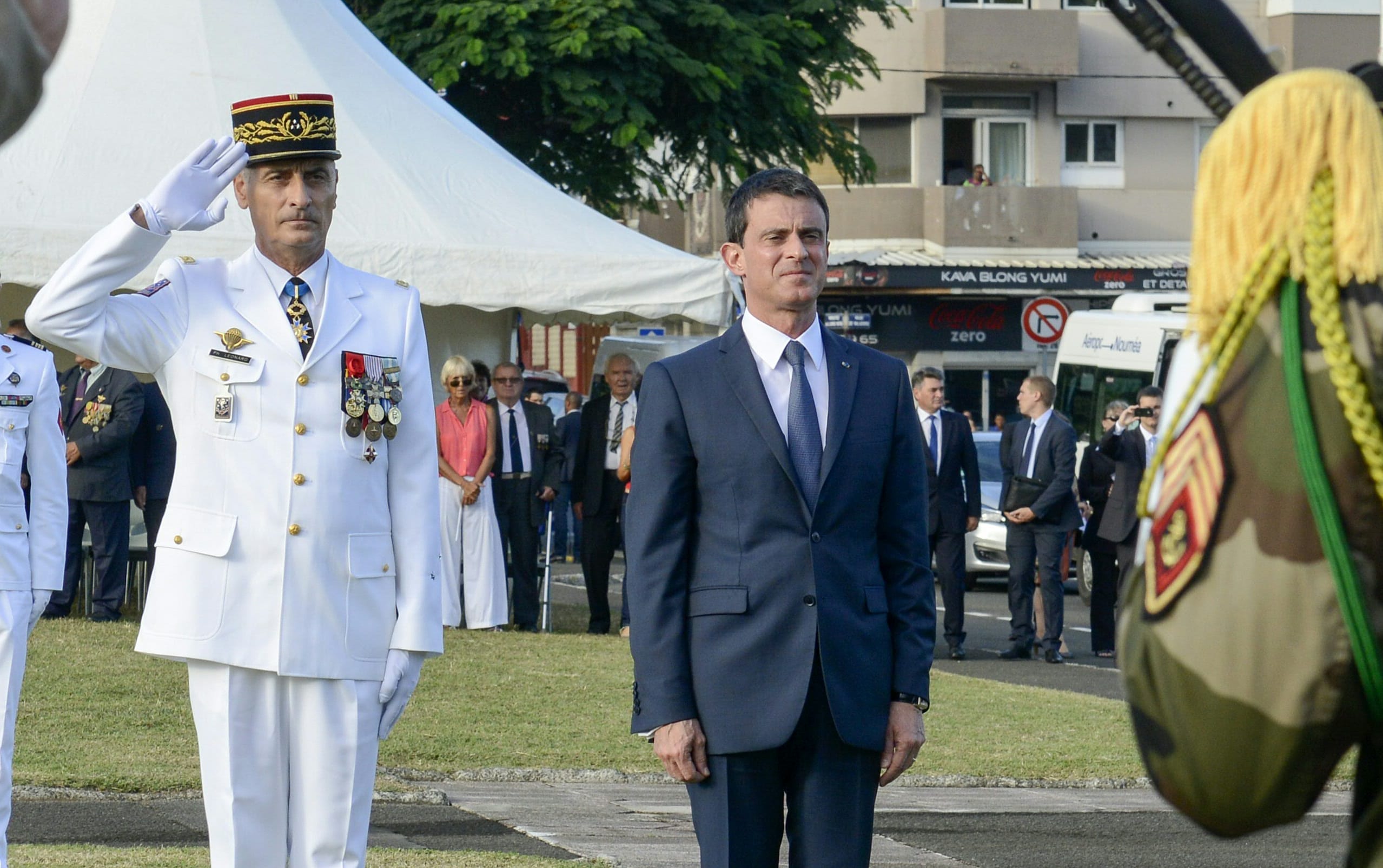 French Commander of the French Armed Forces in New Caledonia, Major General Philippe Leonard, (L) and French Prime Minister Manuel Valls salute at the place Bir-Hakeim in Noumea during a wreath lane ceremony at the wall memorial on April 29, 2016.