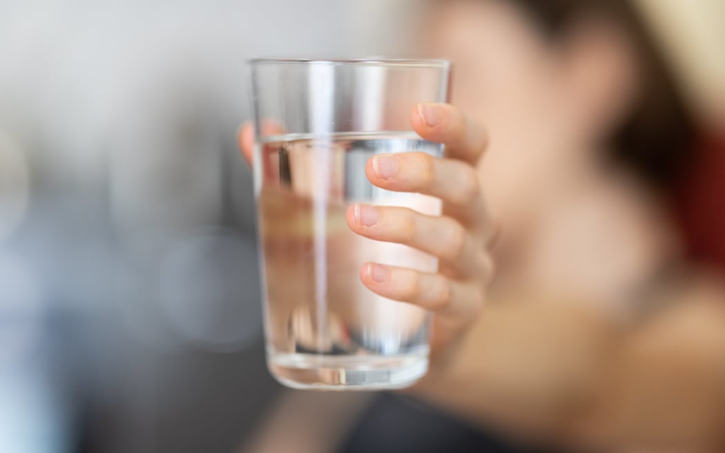 hand holding a glass of water