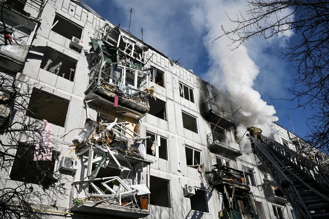 Firefighters work on a fire on a building after bombings on the eastern Ukraine town of Chuguiv on February 24, 2022.