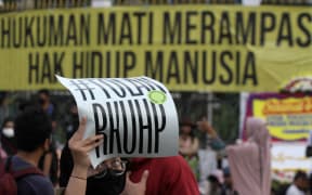 Human rights activists protest outside Indonesia's parliament against draft criminal codes on 5 December, 2022. They reject articles they believe will perpetuate corruption in Indonesia, silence press freedom, and regulate public-private space.