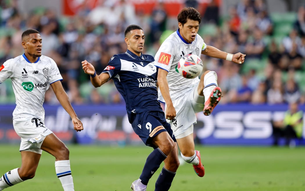 Nikos Vergos of Melbourne Victory FC and Hiroki Sakai of Auckland FC compete for the ball