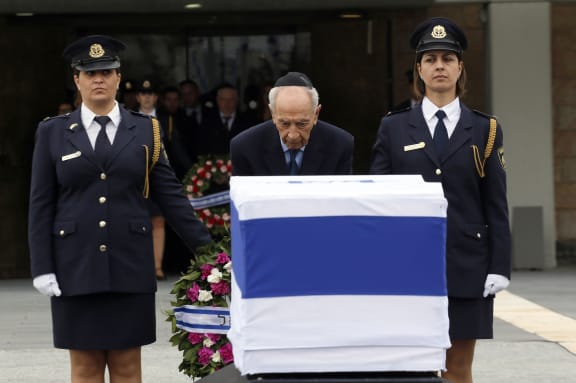 President Shimon Peres lays a wreath by the coffin of Ariel Sharon at the Knesset.
