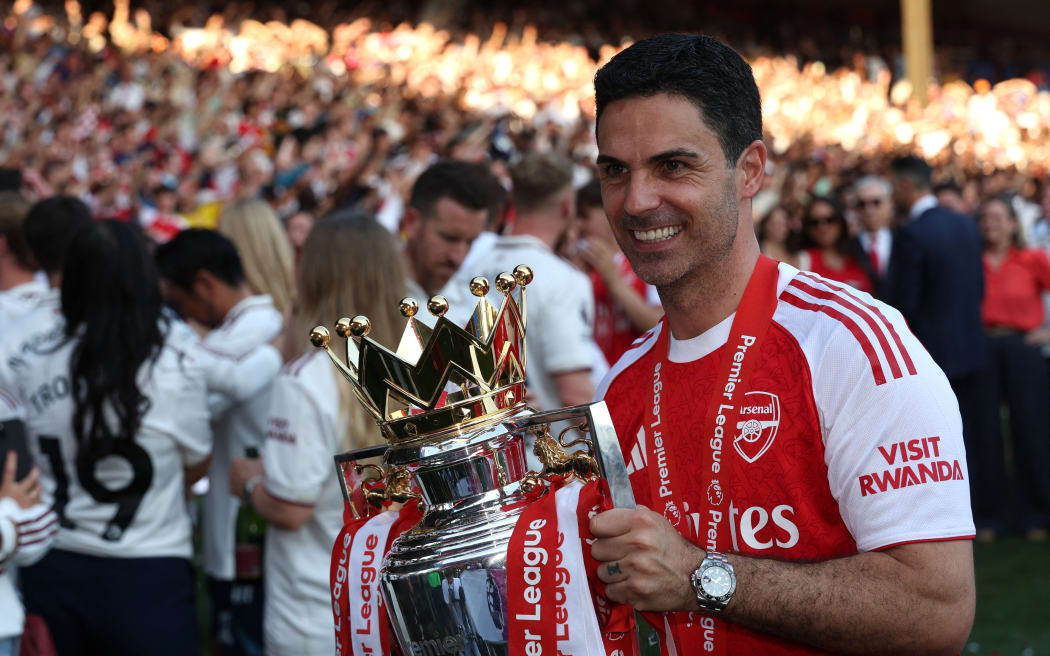 Manajer Arsenal, Mikel Arteta, berpose dengan trofi Premier League.