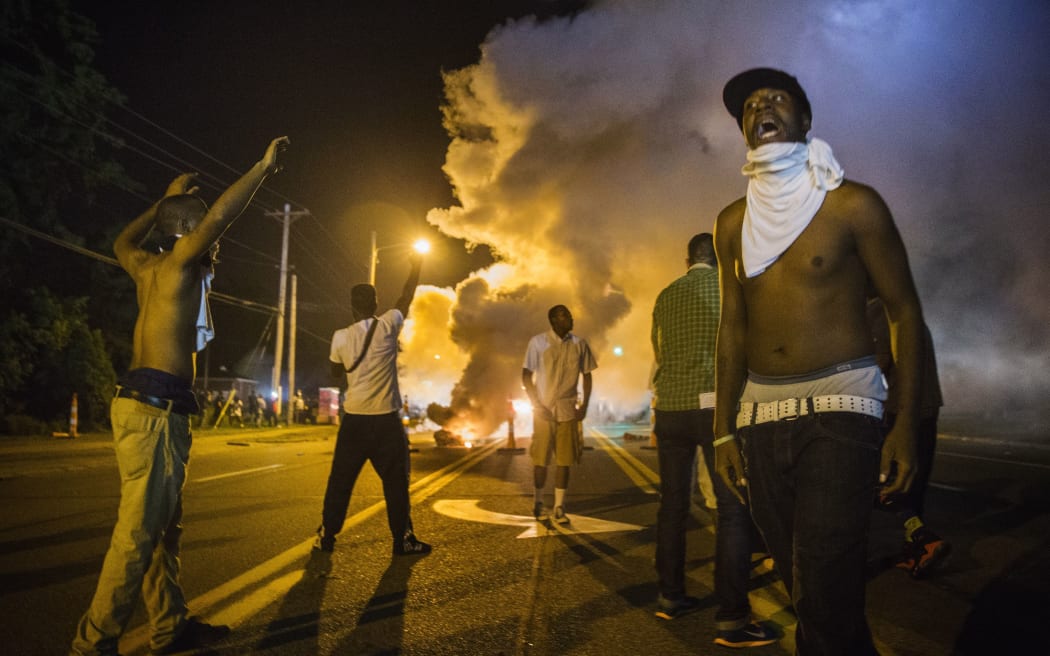 Demonstrators react to tear gas fired by police.